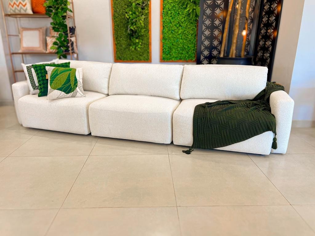 Visão frontal do sofá retrátil Empíreo na cor neutra, destacando o design curvo dos braços e o acabamento premium em uma sala elegante.
