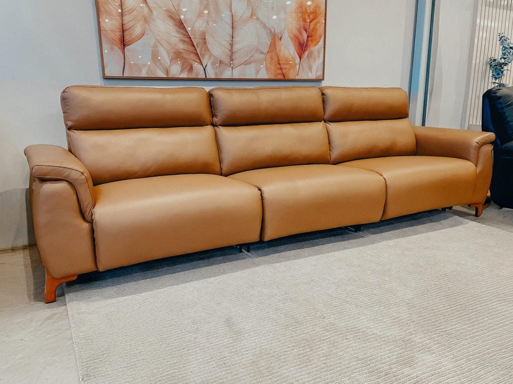 Sofá escuro de couro legítimo Reboot visto em ângulo, com braços curvos e pés altos de madeira, exibindo seu design robusto na posição fechada.