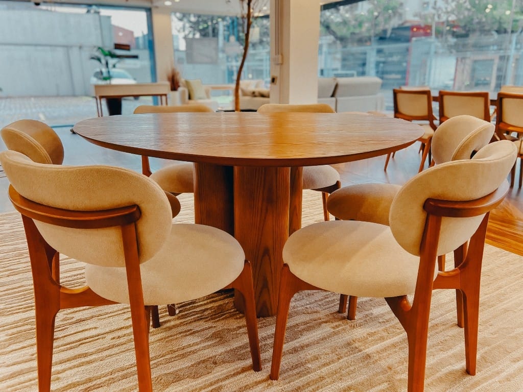 Sala de Jantar Chicago tampo triangular em madeira com base cilindro madeira e cadeira com formato poltrona redonda tecido em bouclé e estrutura em madeira ambientado