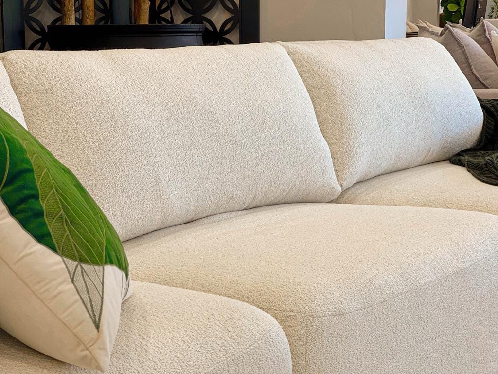 Sofá Empíreo visto em um ângulo de 45 graus, exibindo sua profundidade, design curvo e presença marcante no ambiente.