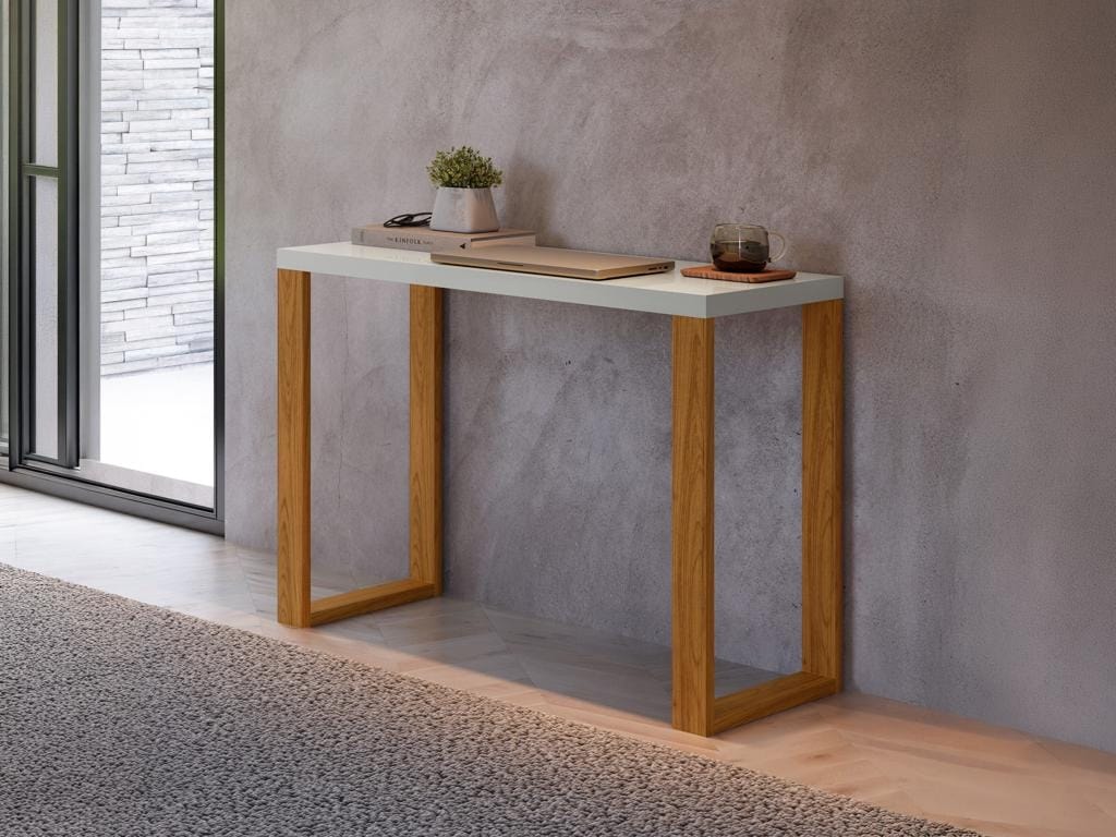 Aparador minimalista modelo F11 com tampo branco grosso e pés de madeira clara, decorado com um notebook fechado e um pequeno vaso de planta, encostado em uma parede cinza de concreto.