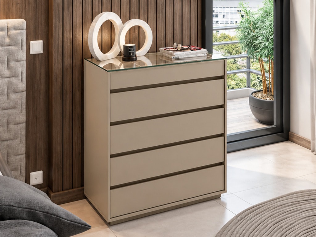 Cômoda Belize Ciello na cor Fendi com tampo de vidro e 5 gavetas, posicionada ao lado de cama e painel ripado amadeirado.