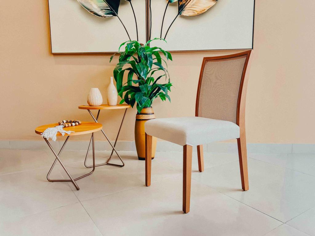 Cadeira Cady Lee Encosto Tela Sala de Jantar Decorada Cadeira de jantar Cady Lee posicionada em ângulo em ambiente decorado com mesas laterais e plantas, destacando o encosto em tela.