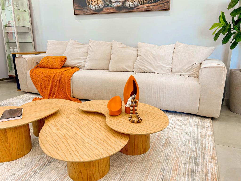 Sofá Despojado Tivoli Estilo Boho Chic Sofá Tivoli visto em ângulo em uma sala de estar iluminada e moderna, exibindo seu design despojado com tecido de caimento solto.