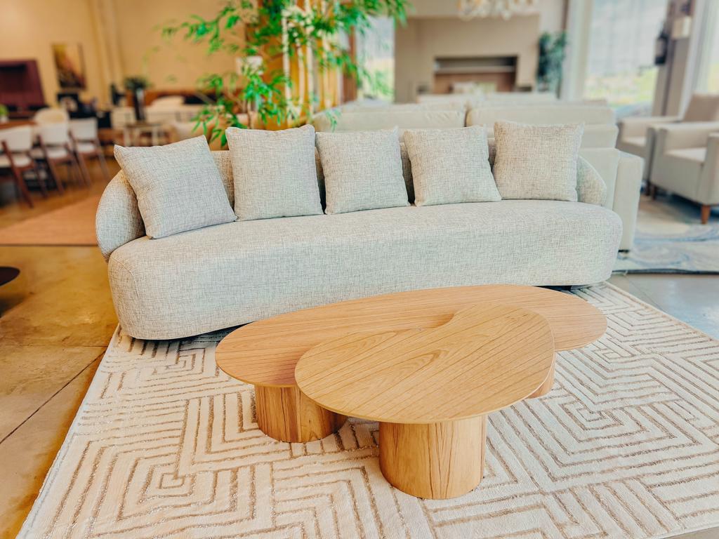 Sofá Orgânico Pluma Design Curvo Ciello Vista ampla e frontal do Sofá Pluma em tecido claro, destacando o seu formato curvo, assento fixo contínuo e design orgânico envolvente.