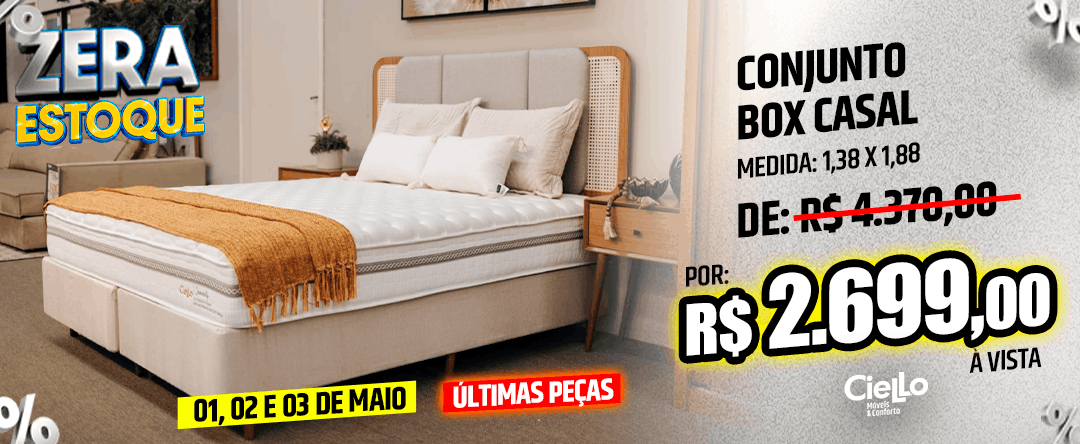 Bedroom with a white upholstered bed and orange throw; ad text reads 'Conjunto Box Casal', original price crossed out, 'R$ 2.699,00' à vista, May 1–3 promo.