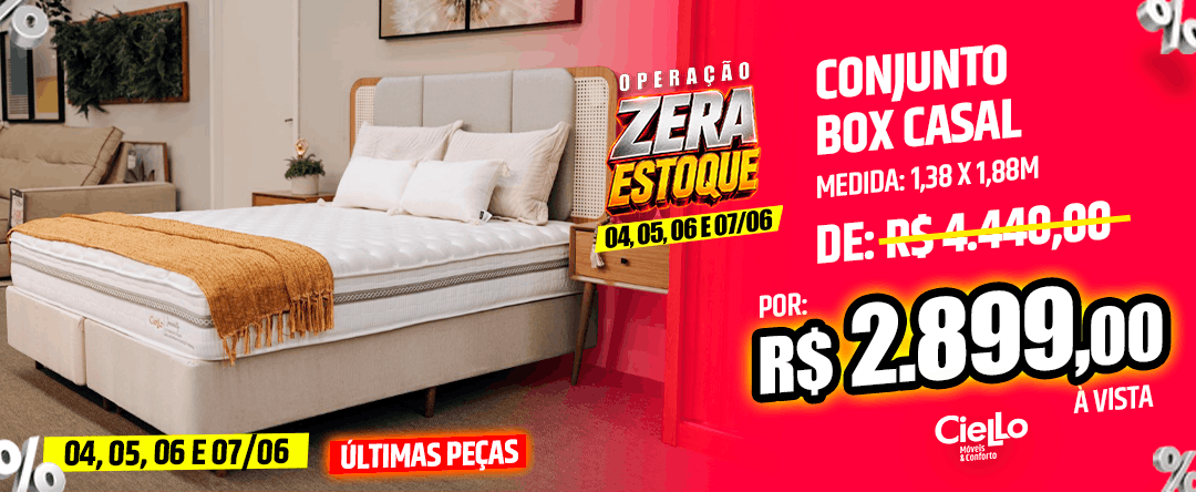 Bedroom with a white upholstered bed and orange throw; bright pink sale banner on the right advertising Conjunto Box Casal from R$2.899,00