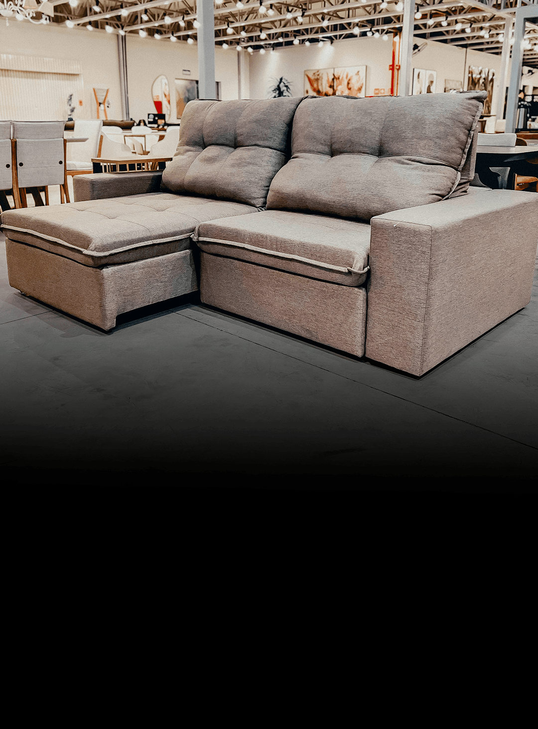 Grey fabric L-shaped sectional sofa with chaise in a furniture showroom.