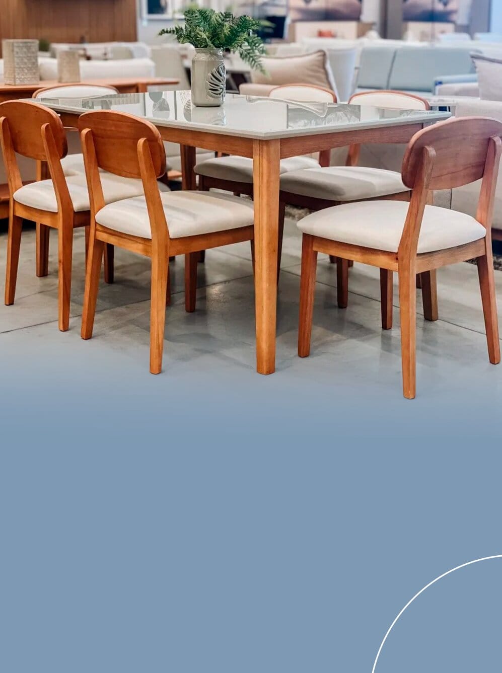 Mesa de jantar retangular com tampo claro acompanhada de seis cadeiras com pés de madeira, assentos estofados claros e encostos ergonômicos de madeira curvada.