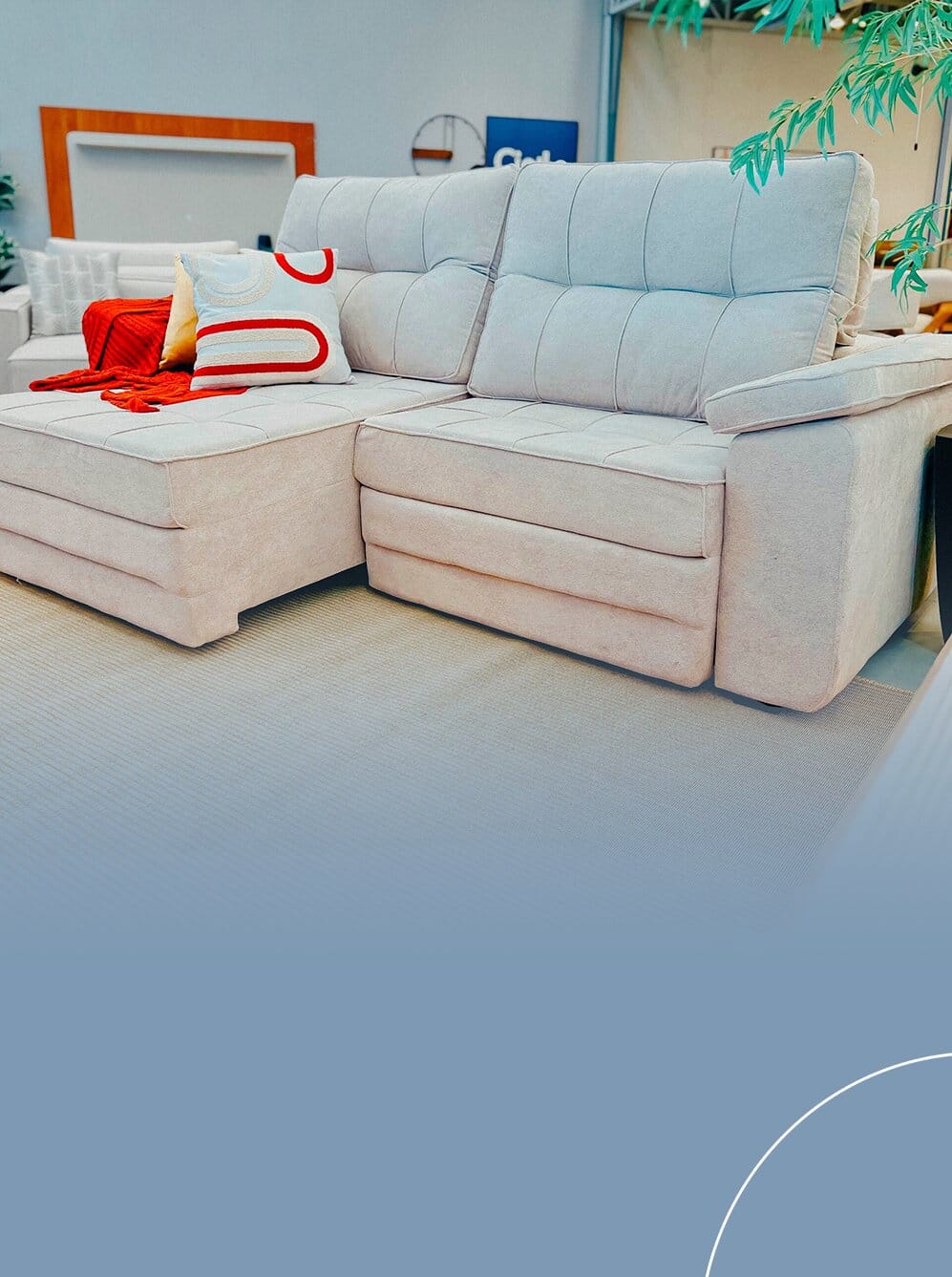 Sofá retrátil e reclinável na cor bege claro, com uma chaise estendida, almofadas decorativas coloridas e uma manta vermelha sobre o assento.