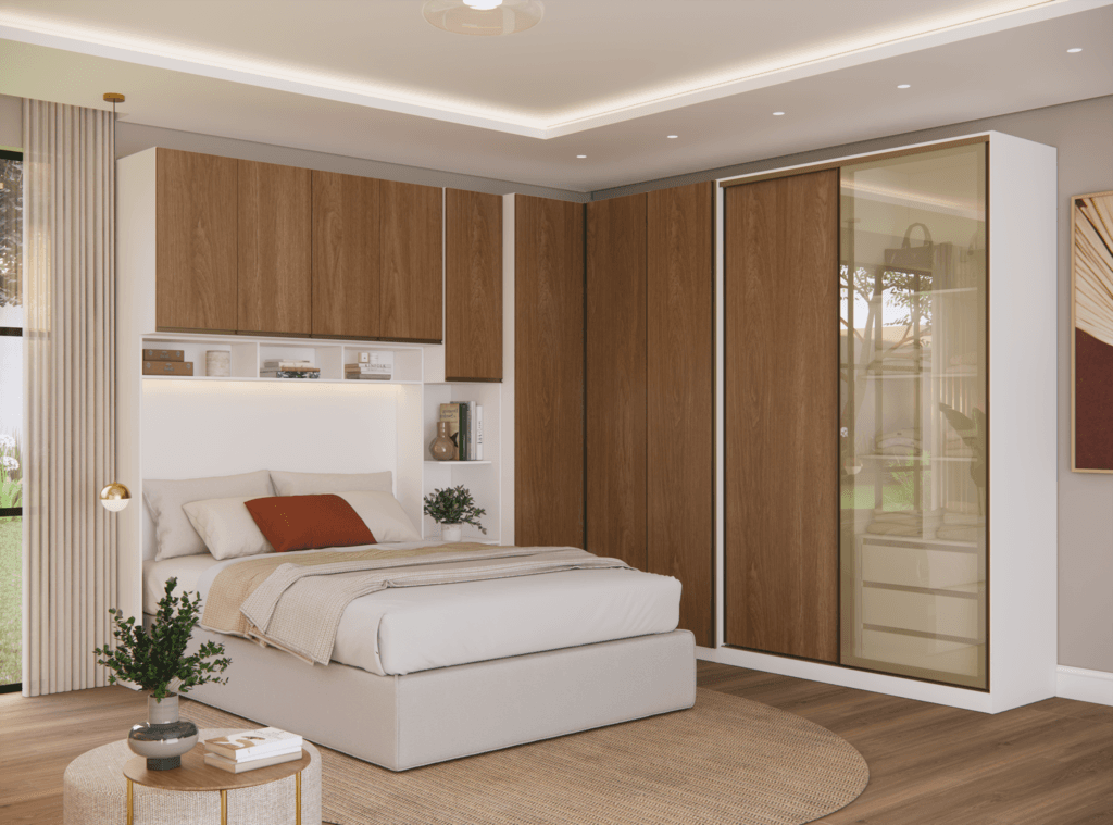 Roupeiro Modulado Casal Madeira e Vidro Quarto de casal contemporâneo decorado com móveis modulados em formato de L. O conjunto apresenta caixaria branca e frentes em tom amadeirado, destacando-se à direita um roupeiro com porta de correr em vidro reflecta bronze que revela o interior. Ao centro, uma cama de casal posicionada sob um armário de ponte com nichos brancos iluminados.